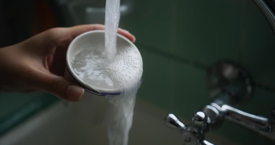 A person filling up a cup of water