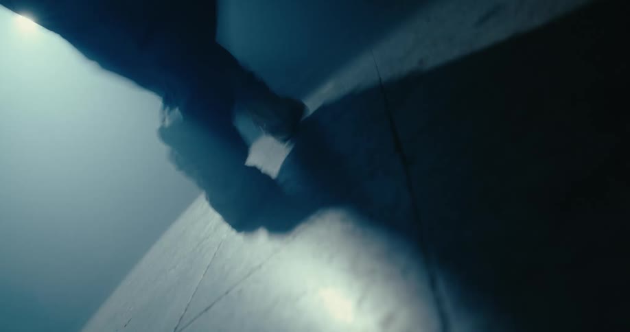 A man break dances in a dark room