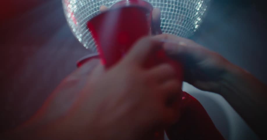 A group of people are dancing and drinking alcohol at a club