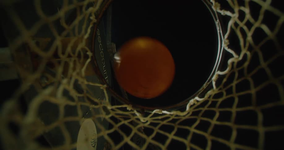 Close up view of a basketball being thrown into a net