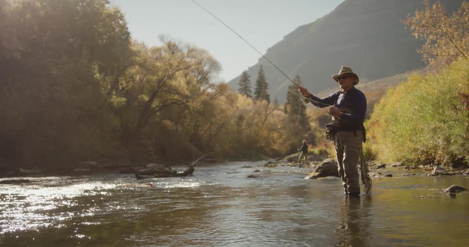 A man is fly fishing in the creek