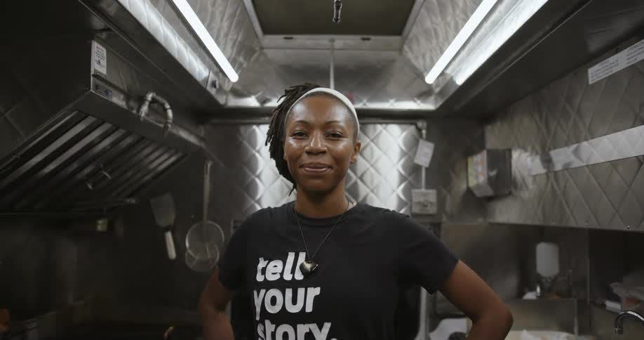 Young happy woman standing on a restaurant kitchen looking at the camera
