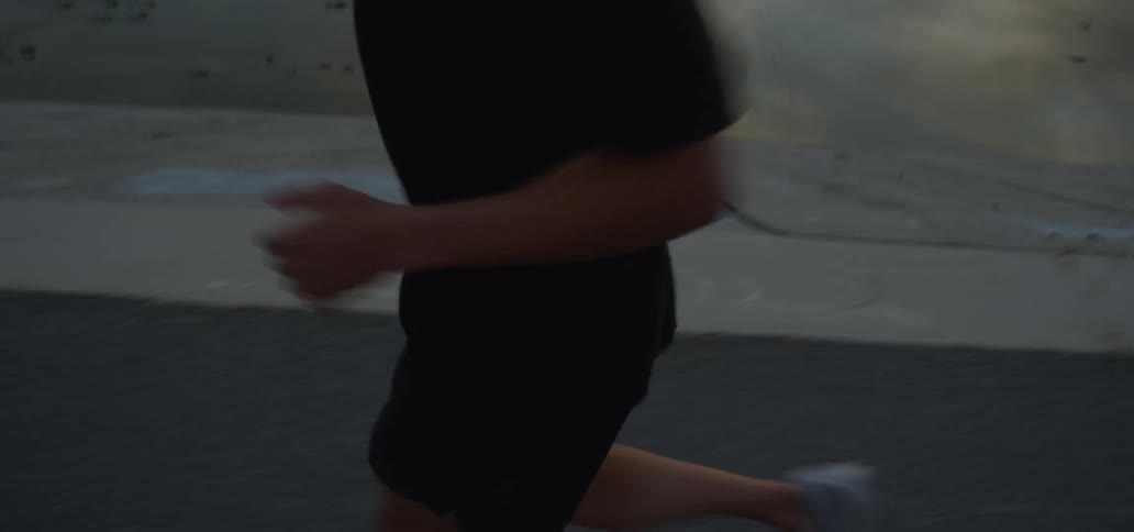 Young man jogging on a road near a canal at morning