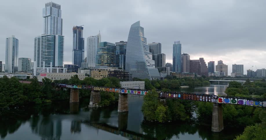 A modern city is next to a river lined by trees