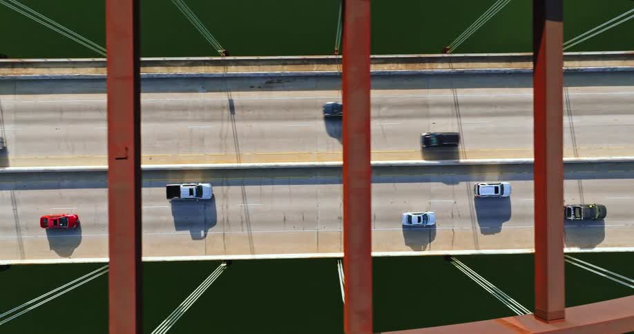 Cars are driving on a bridge over a body of water