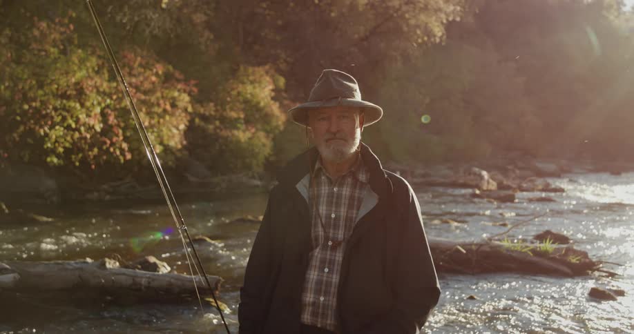 A man is standing on a river with fishing gear