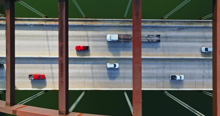 The vehicles drive over the bridge