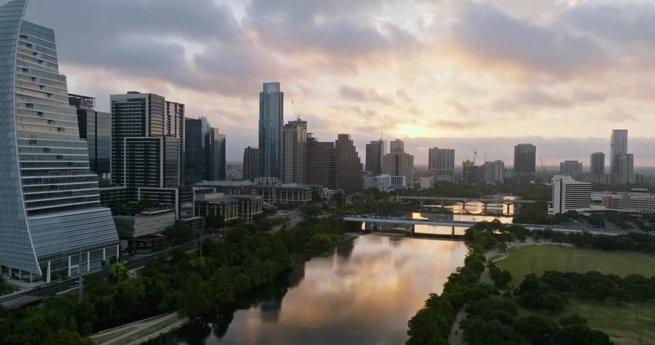 Aerial view of office buildings next to river at sunset in the city