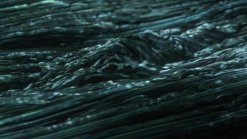 Light reflects on the ripples of a dark liquid as it waves and moves