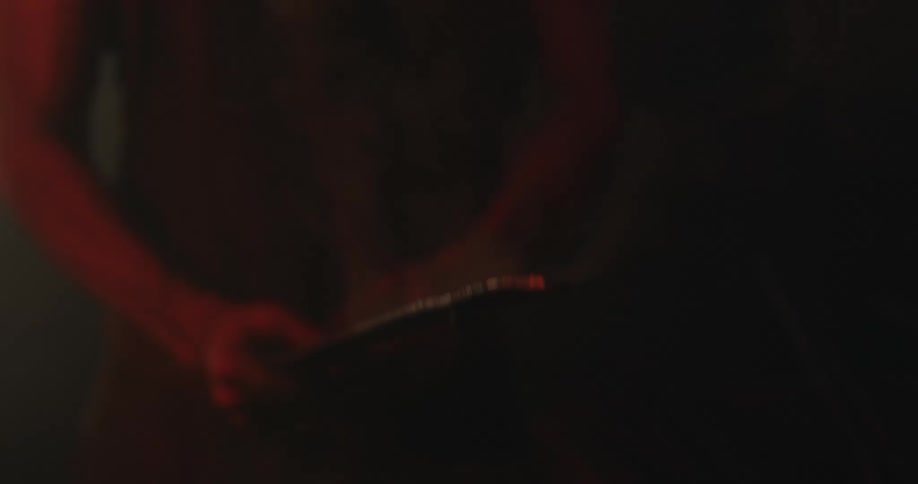 A blacksmith pulls a piece of molten hot metal out of water as smoke floats in the air