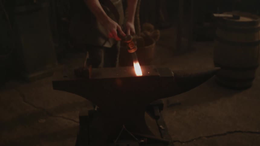 A blacksmith hammering a piece of hot metal