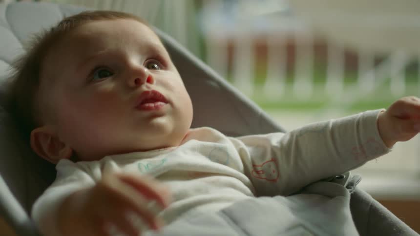 A baby rocking in a baby bouncer