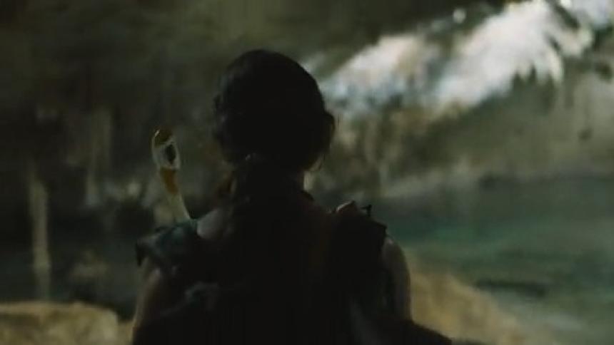 Woman holds a flashlight as she hikes through a cave