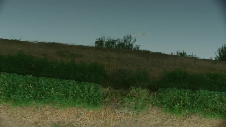 A dynamic and creative shot looking at the reflective surface of an irrigation canal as the camera dolly's along for a unique perspective of water use in the arid west