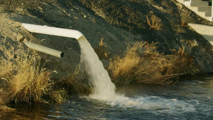 Water being pumped into an irrigation canal - many straws drinking out of one resource