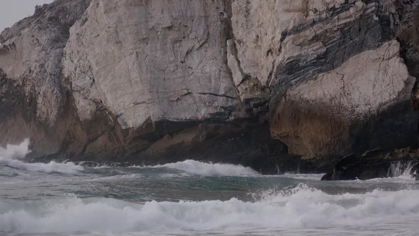 Waves crash against the rocks on the shore