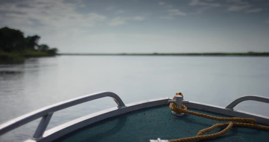 A boat travels across a waterway during the day