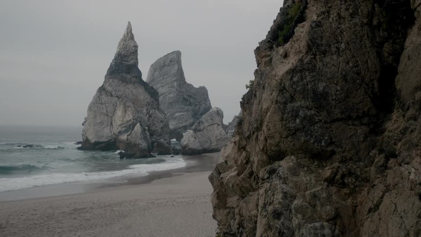 Waves crash on the shore on a cloudy day