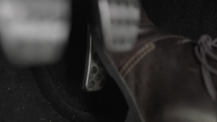 A foot presses the gas pedal of a vehicle
