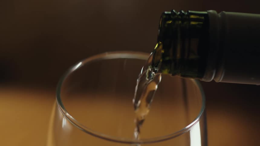 Closeup of drink being poured into glass from bottle