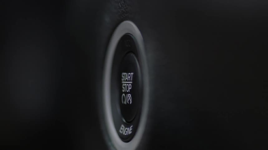 Someone pushes the start button on a car