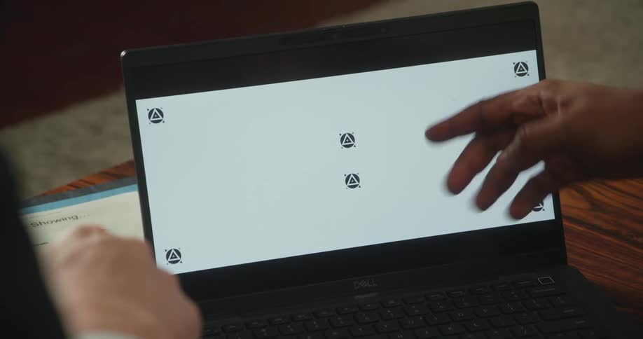 Two men discussion information on a laptop screen