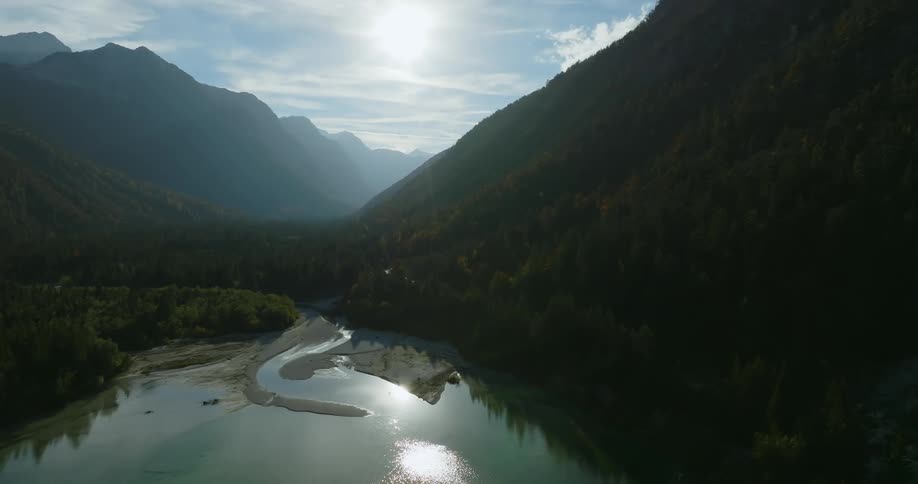 Trees on the side of a canyon reflect off the lake below