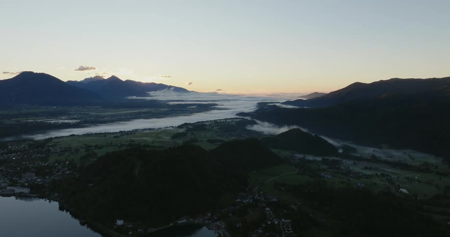 Aerial view of coastal town near mountain forest at dusk