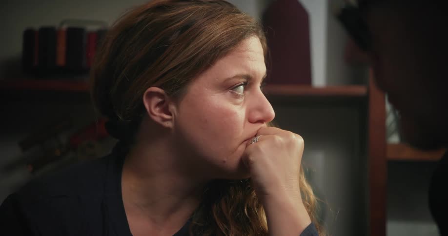 A couple sitting in a room and the female appears sad