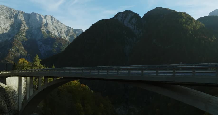 A concrete and iron bridge runs through a mountain range