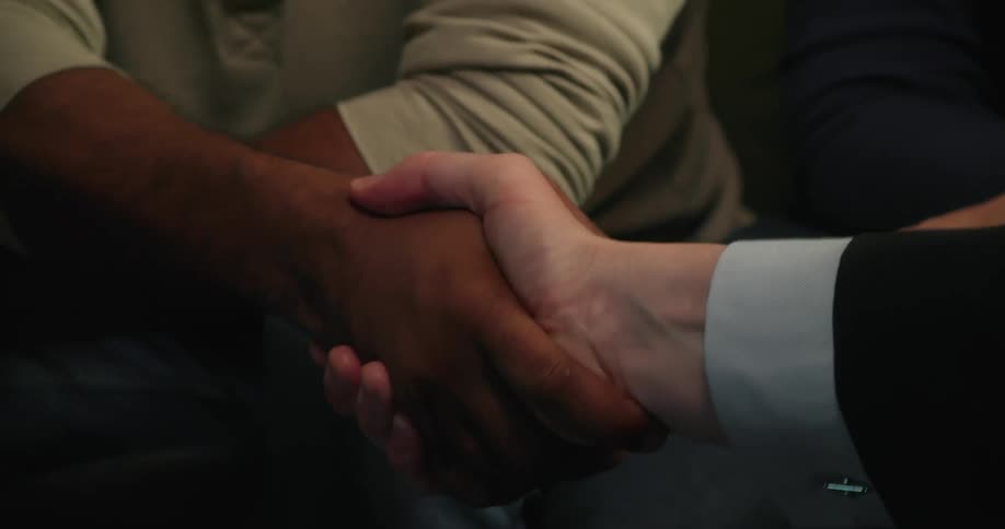 People sitting shake hands