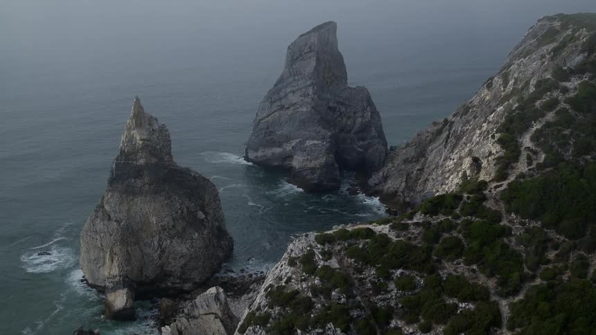 Large rock formations near a mountainous coast line