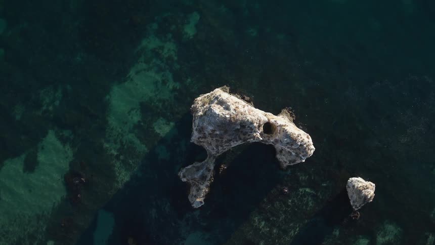 A rock is sticking up out of the water below