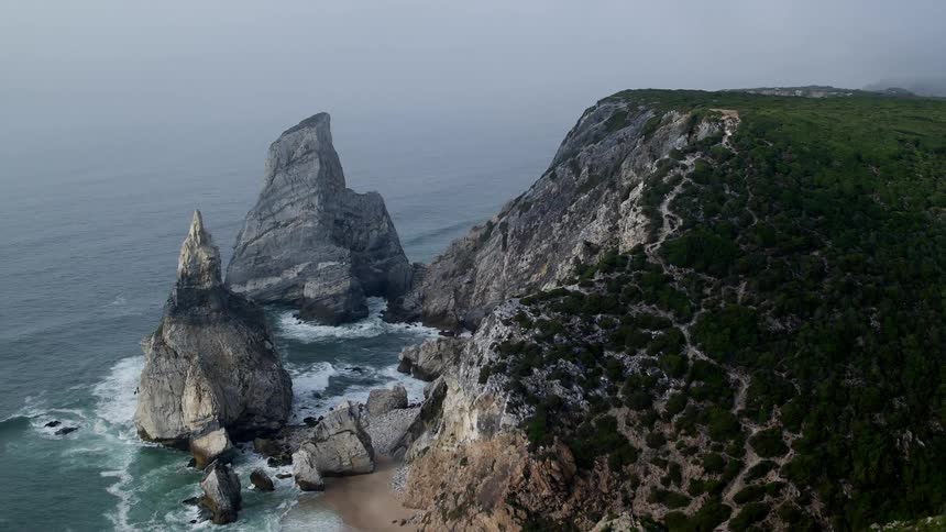 A beautiful view of the cliffs while white waves crash below on the rocks