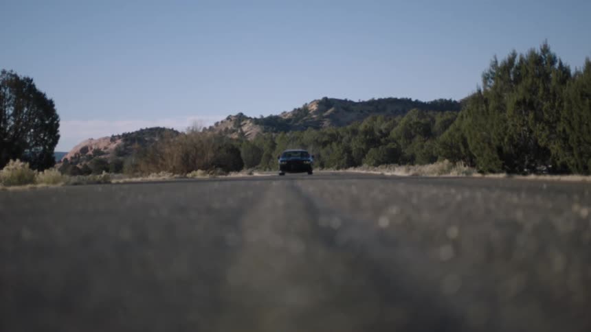 A car sits idle on a two lane road