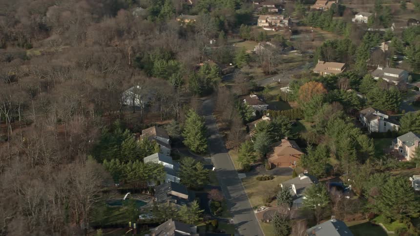 An aerial flyby of suburban homes in Syosset Long Island captured during winter