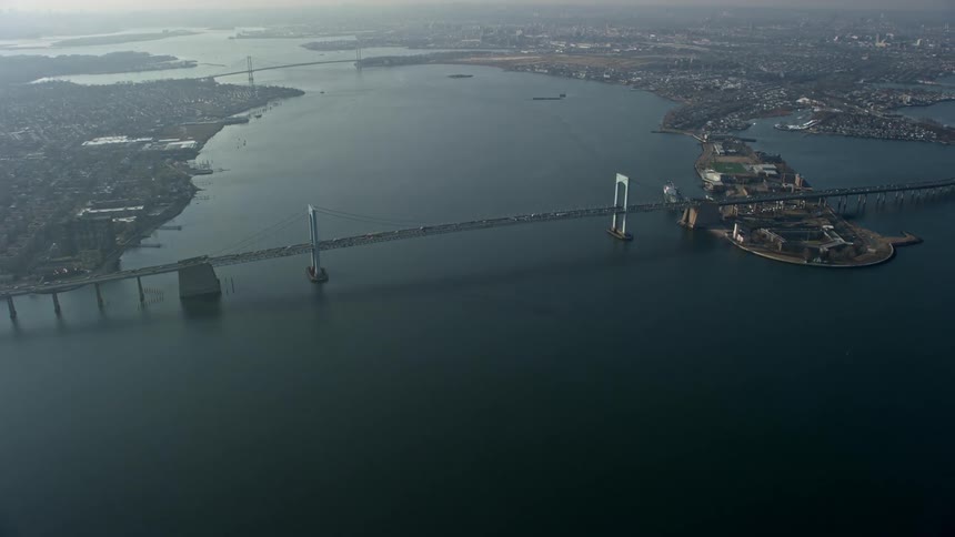 Aerial view of traffic moving along the Throgs Neck Bridge in New York City spanning the East River on a hazy winter day