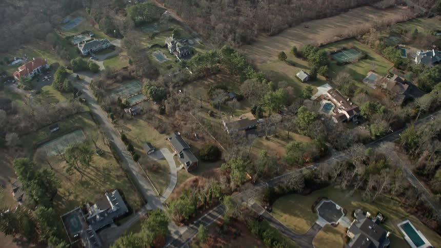 An HD aerial view of upscale homes in Syosset Long Island New York during a sunny winter day