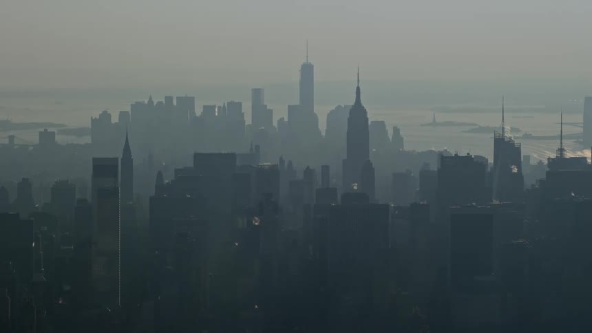 Aerial footage of Empire State Building Midtown Manhattan and Lower Manhattan skyscrapers in winter haze New York City