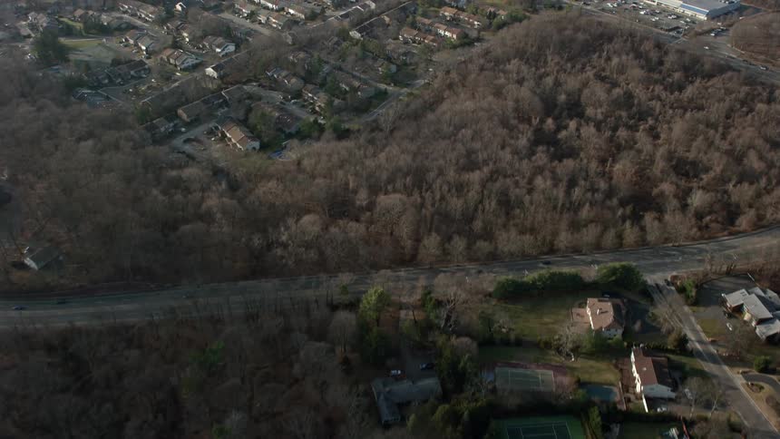 A 4k aerial footage of upscale homes and leafless trees during winter revealing a condo complex in Woodbury Long Island New York