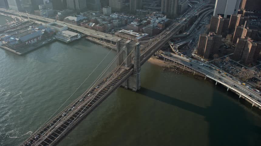 Traffic congestion as vehicles leave Lower Manhattan on the iconic Brooklyn Bridge during winter viewed from a high-altitude aerial footage