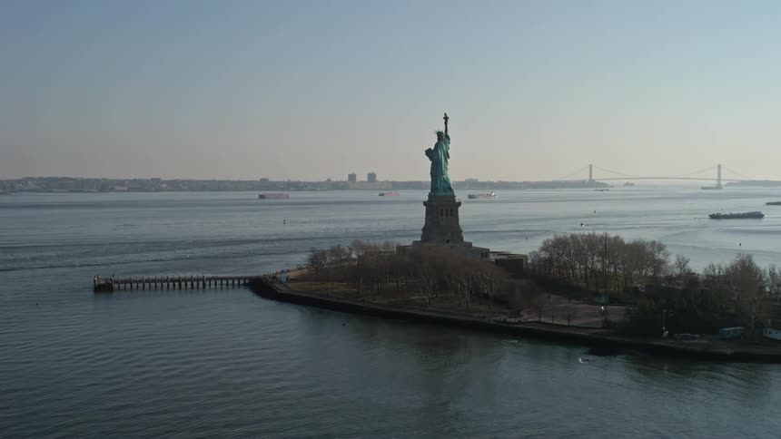An aerial flyby of the back of the Statue of Liberty during winter in New York City