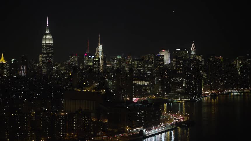 Aerial footage of New York Citys power plant Empire State Building and Midtown skyline on a clear winter night showcasing the citys historical high rise and industrial landmarks