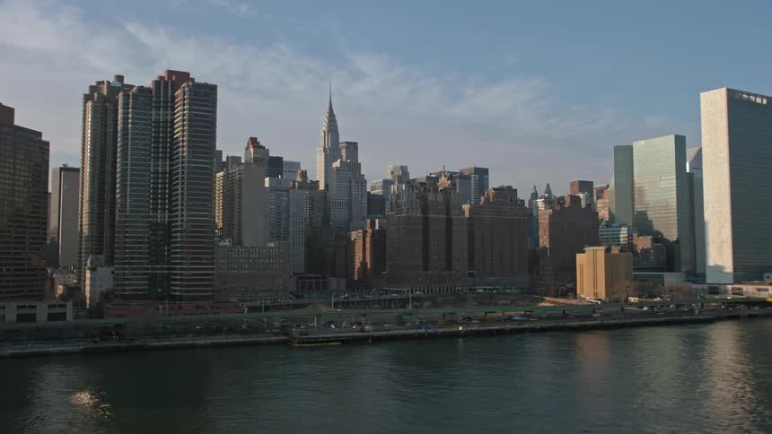 Aerial footage of Midtown Manhattans United Nations and skyscrapers during winter with daylight and sunshine highlighting the citys famous government and residential buildings