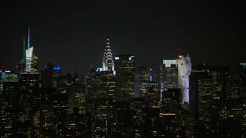 A 4K aerial footage of the iconic Chrysler Building and skyscrapers of Midtown Manhattan illuminated at night during a winter night in New York City