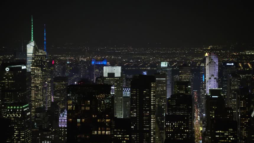 Aerial view of Midtown Manhattan skyscrapers towering above the city lights at night during winter