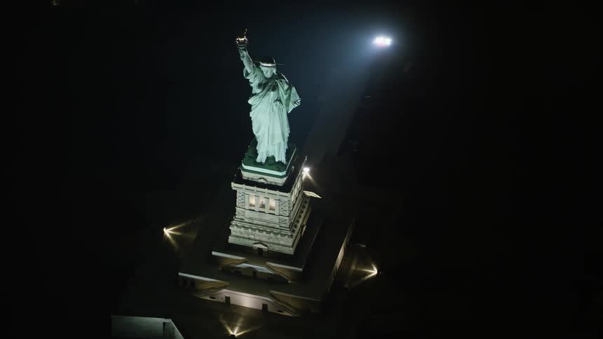 Approaching the historic Statue of Liberty at night from the birds eye view with a tilt down to capture its grandeur