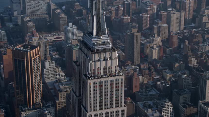 Aerial view of the Empire State Building standing tall amidst other skyscrapers in Midtown Manhattan New York City during a clear winter day