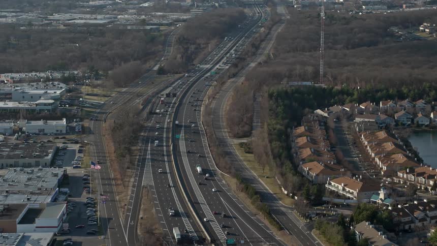 A flyover clip of the Long Island Expressway and office buildings with light traffic during winter in Melville NY