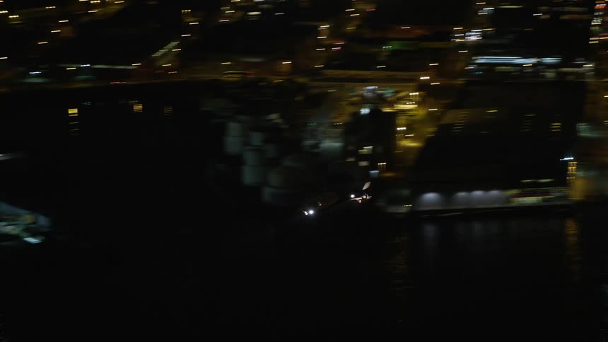 A helicopter soars above the Midtown Manhattan riverfront at night during winter